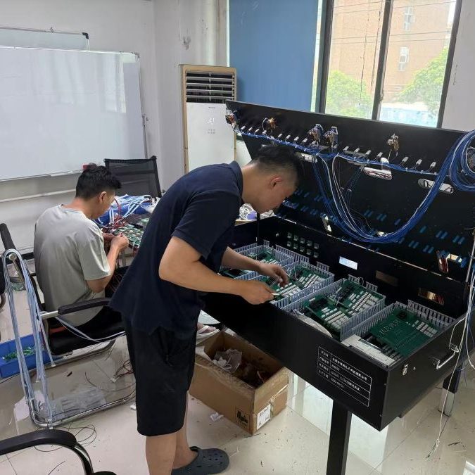 Technician assembling and debugging large ATE test fixture equipment in workshop