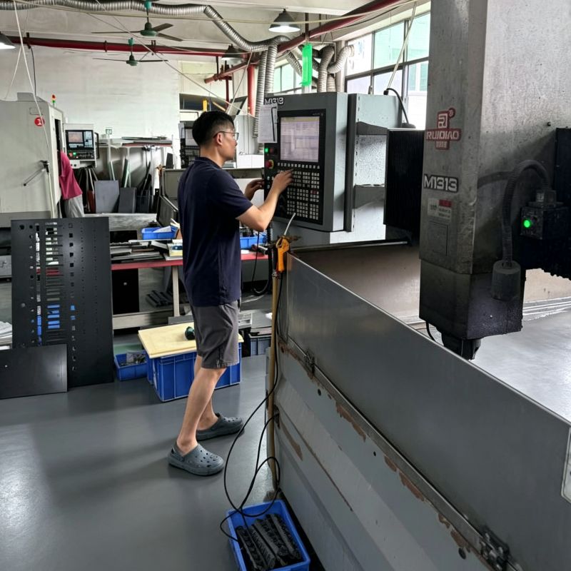 Factory workshop scene, operator programming CNC machine for custom fixture and jig precision machining production