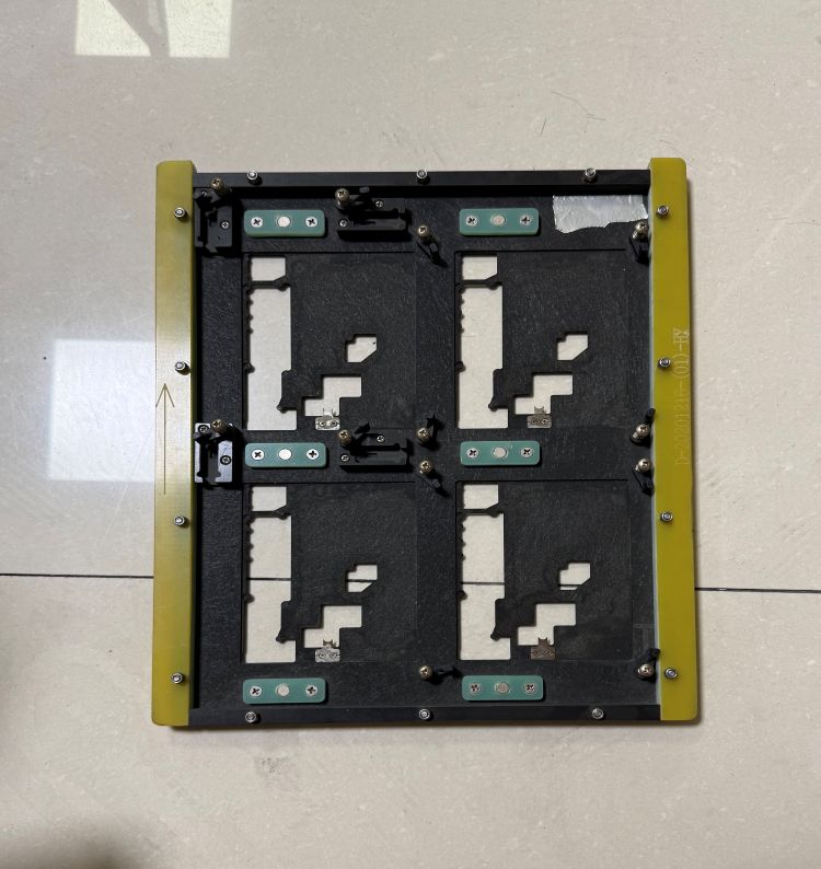 4-up quad cavity SMT wave soldering fixture, black composite carrier with yellow fiberglass border, four custom PCB cavities and adjustable positioning clips