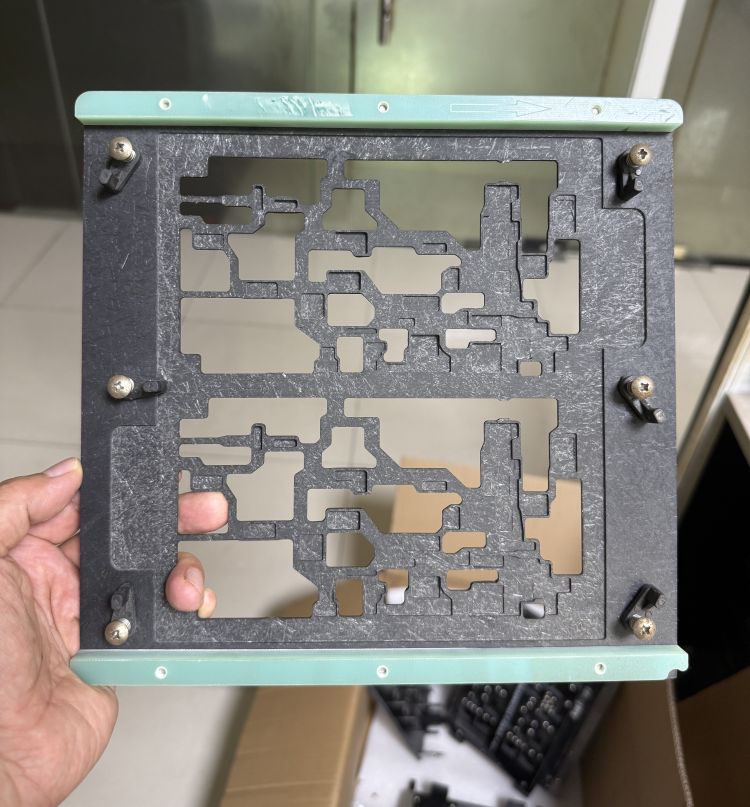 Lightweight green edge SMT wave soldering fixture, black thin composite plate with green fiberglass top edge, irregular multi-shape cavities for mixed PCB outlines