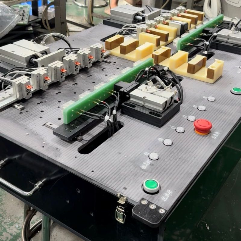 Work‑station assembly view of long‑base multi‑channel parallel PCBA test rig in workshop